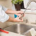 Handyman fixing a leaky faucet Az Express Plumbing Plumber repairing a leaky kitchen faucet