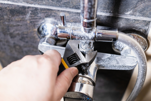 plumber fixes nut of shower faucet close up Az Express Plumbing Expert leak repair service in San Tan Valley AZ