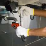 Plumber fixing white sink pipe with adjustable wrench Az Express Plumbing Plumber fixing a sink pipe with an adjustable wrench