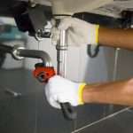Plumber fixing white sink pipe with adjustable wrench Az Express Plumbing Plumber fixing a sink pipe with an adjustable wrench