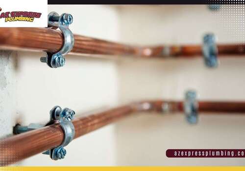 Flexible red and blue PEX plumbing pipes installed alongside rigid copper water supply lines