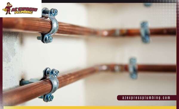 Flexible red and blue PEX plumbing pipes installed alongside rigid copper water supply lines