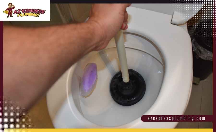 Using a rubber flange plunger to clear a clogged toilet bowl